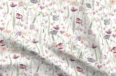 a white fabric with pink flowers and butterflies on the front, along with green leaves