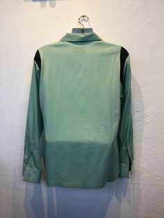 "1950s vintage reproduction Hollywood Rogue two tone mint green and black shirt The shirt has a two tone design with mint green and contrasting black on shoulders and neckline. The garment has a loop collar, five button down front, one patch pocket and long sleeves. The label reads \"Hollywood Rogue\" and the shirt is in new unworn condition. As with all clothes made by \"Hollywood Rogue\" this shirt was made in an original 1950's design and is only available in very limited numbers. Made in Cal Classic Green Johnny Collar Tops, Retro Green Button-up Top, Retro Green Collared Shirt, Retro Black Long Sleeve Shirt, Retro Black Tops For Work, Retro Black Workwear Shirt, Retro Black Shirt For Work, Vintage Black Workwear Shirt, Vintage Black Shirt For Work