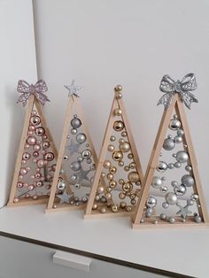 three wooden christmas trees with ornaments on them