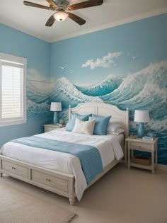 a bedroom decorated in blue and white with waves painted on the wall behind the bed