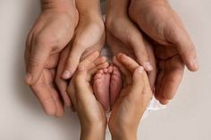 two adults and one child holding their hands together