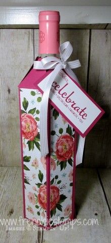 a pink bottle with flowers on it and a ribbon tied around the top