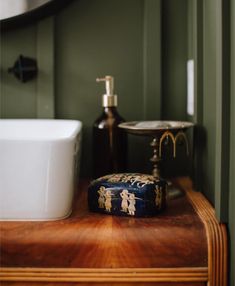 a bathroom with green walls and wood flooring