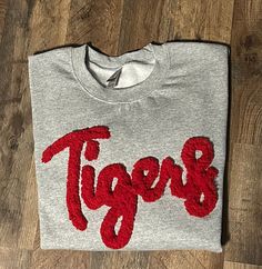 Show your school spirit in this cute sweatshirt. Comfort, casual and loose fitting, made on 50/50 cotton/poly blend shirts.  Embroidered chenille yarn, Tigers sweatshirt.  Please message us if you have a custom color request and we will create a separate listing for custom requests.  You can follow us at the below link for chances to win giveaways and to see all of our latest creations.  https://www.facebook.com/groups/710060383256657/?ref=share&mibextid=S66gvF Kentucky Sweatshirt, Purple Cat, Cat Sweatshirt, Cute Sweatshirts, Blue Cats, Grey Sweatshirt, School Spirit, Custom Color, Loose Fitting