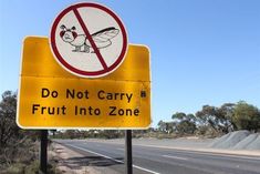 a yellow sign that says do not carry fruit into zone