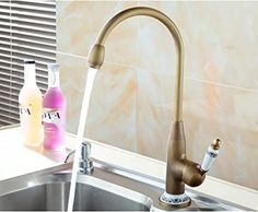 a faucet running water in a kitchen sink next to a bottle of cleaner