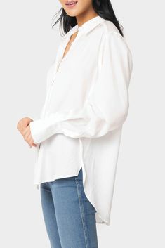 The white shirt has got a new look for the season with details that make this perfect for every look. This chic and easy button-front blouse in our satin effect fabric has 5 ways to wear. Open or closed, layered over a simple tee with leggings, front-tied for creating the look of the season, casually front-tuck one side for the perfect day-look with denim, or tucked in for an elevated wear-to-work look. 62% Polyester | 38% Rayon Delicate Wash Cycle, Dry Flat. Length 26 1/2" (size small) Front Bu Solid Color Button-up Tops For Layering, Versatile Button-up Tops For Layering, Spring Layering Shirt With Button Cuffs, Spring Shirt With Button Cuffs For Layering, Versatile Blouse With Button Cuffs For Daywear, White Button-up Tops For Layering, Classic Spring Blouse For Layering, Versatile White Button-up Top, Classic Blouse For Brunch