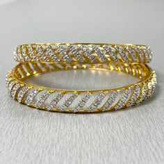 The Curves Bangles Set is inspired and created to reflect Indian tradition and design. With diamonds studded in a yellow gold, these bangles exude an ethereal glow. Total Diamond Weight: 7.70 ct No. of Diamonds: 400Diamond Color: G - HDiamond Clarity: VS Metal: 18K Yellow GoldMetal Wt: 34.46 gms Setting: Prong Set Inner Diameter: 2.4 Inches (6.10 cm) Fine Jewelry White Bangle With Single Cut Diamonds, White Bangle With Single Cut Diamonds, Gold Diamond Bracelet With Sparkling Detail For Anniversary, Gold Sparkling Diamond Bracelet For Anniversary, Yellow Gold Wedding Bangle With Diamond Accents, Wedding Diamond Cut Yellow Gold Bangle, Diamond Sparkling Bangle For Anniversary, Elegant Gold Sparkling Bangle, Gold Sparkling Diamond Bangle Bracelet