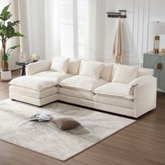 a living room with a large sectional couch and rug on the floor in front of it