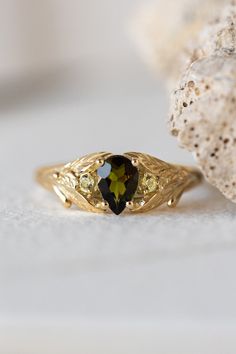 a close up of a ring with a stone in the middle and a rock behind it