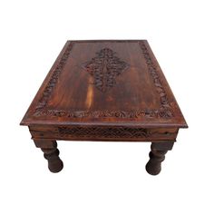 an old wooden table with carvings on it