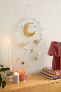 a table topped with a lamp next to a wall mounted moon and star dream catcher