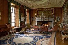 an ornate living room with wood paneled walls and flooring is pictured in this image