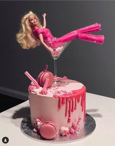 a barbie doll sitting on top of a cake with pink icing dripping from it