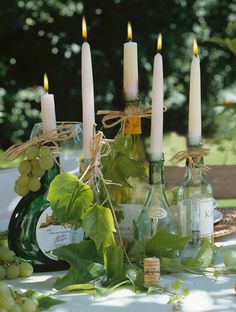 wine bottles and candles sitting on a table