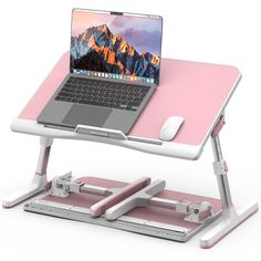 a laptop computer sitting on top of a pink and white stand with a mouse in front of it