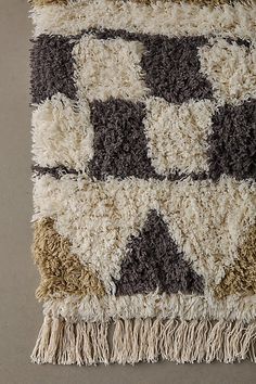 a multicolored rug with fringes on the bottom and one side that has squares