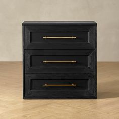 a black and gold chest of drawers on a wooden floor