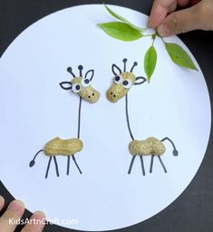 two giraffes made out of paper on top of a white plate