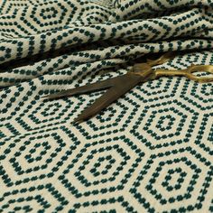 a pair of scissors laying on top of a patterned fabric