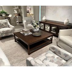 a living room filled with lots of furniture and flowers on top of a coffee table