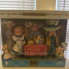 the doll is in its box and has two figurines on top of it