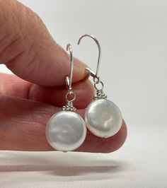 Coin Pearl Earrings. Sterling Silver Leverback Earrings. June Birthstone Gift for Her. The earrings are handmade using sterling silver and freshwater pearl components. The pearls are coin shaped and measure ~12 mm wide, they are white pearls with subtle pink overtones and a few natural bumps and wrinkles are seen in the surface. The pearls are complemented by bright Bali daisies. Total length of the earrings is 1 3/16 inch (3.0 cm) for French hook and 1 5/16 inch (3.3 cm) for leverback. Choose e