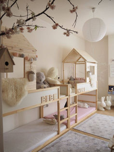 a child's room with bunk beds and stuffed animals on the shelves, in front of a cherry blossom tree