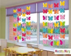 colorful butterflies are hanging from the windows in this school classroom setting with tables and desks