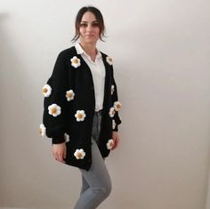 🌼 Effortlessly chic and cozy, our Daisy Knit Cardigan is the perfect addition to any wardrobe. Embrace the elegance and warmth of this exquisite cardigan sweater, tailored for those who appreciate the finer things in life. 💐 Unique Floral Cardigan: Stand out with our charming floral design, featuring delightful daisies that add a touch of spring to your look year-round. Be the epitome of grace with this captivating oversized cardigan that's both stylish and comfortable. 🖤 Timeless Black Cardi Daisy Cardigan Outfit, Woolen Cardigan Design, Woolen Cardigans For Women, Cozy Black Sweater For Spring, Cozy Black Sweater Coat For Spring, Cozy Black Spring Sweater, Cozy Black Spring Cardigan, Black Daisy, Cardigan For Women