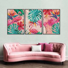 two pink couches with paintings on the wall behind them