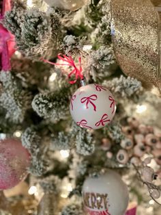 a christmas tree decorated with ornaments and pink bows