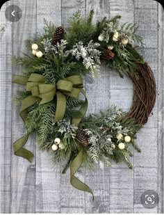 a christmas wreath with pine cones and greenery