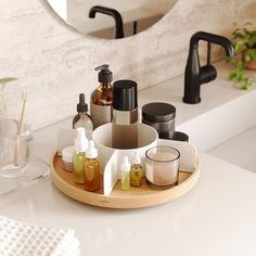 a bathroom counter with soap, lotion and other personal care items in front of a mirror