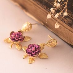 This lovely earrings are really cute, made of a resin handpainted purple-pink flower in a golden rose base. Gold plated filigree post earrings. Size from your piercing: 3.5 cms ( 1.30 Inches) Please note my jewelry is not waterproof, please avoid bathing and perfumes.  Please note the colors could vary slightly on each screen. If you have any question feel free to ask me! Your order comes in a gift box or a gift bag, so, it is ready for gift giving Thanks for looking! Pink Enamel Flower-shaped Earrings, Pink Flower-shaped Enamel Earrings, Pink Flower Enamel Earrings, Flower Shaped Earrings With Rose Design For Gift, Flower-shaped Rose Design Earrings For Gift, Flower Shaped Rose Design Earrings For Gifts, Rose Design Flower Earrings As Gift, Flower Rose Design Earrings As Gift, Handmade Purple Clip-on Earrings For Gift