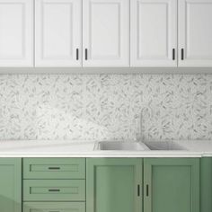 a kitchen with white cabinets and green cupboards next to a sink in the middle