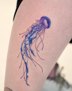 a woman's thigh with a jellyfish tattoo on it