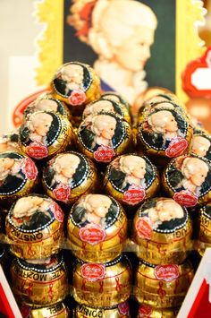 a pile of chocolate covered candies sitting on top of a red stand next to a painting