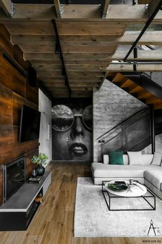 a modern living room with wood floors and exposed ceilings, white couches and coffee table