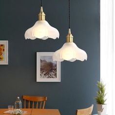 three lights hanging over a dining room table