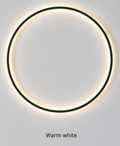 an illuminated circle with the words warm white on it in front of a gray background