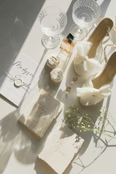 a table topped with white flowers and wedding shoes