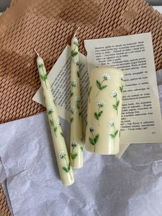 three candles sitting next to an open book