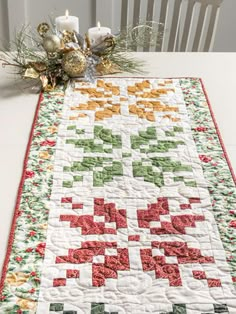 a quilted table runner with candles on it