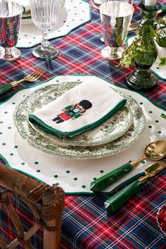 a table set for christmas dinner with plates and utensils