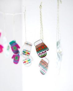 five colorful mittens hanging from strings in a room