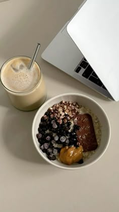 a white plate topped with food next to a cup of milk and a laptop computer