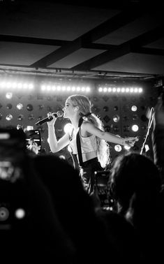 a woman standing on top of a stage holding a microphone