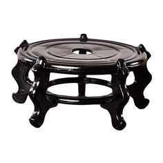 a black glass tray with two legs and an ornate design on the bottom, sitting in front of a white background