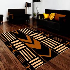 a living room with black couches, yellow pillows and wooden flooring in it